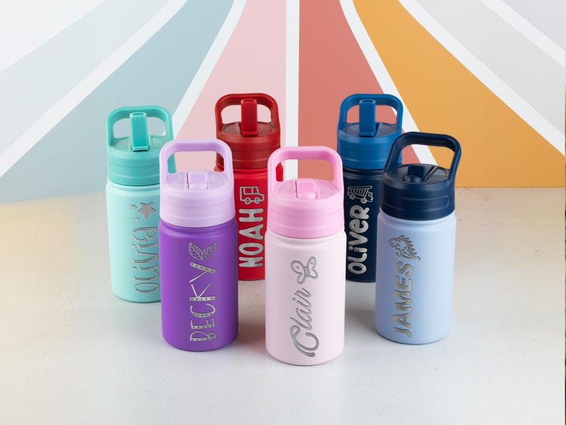May include: Six stainless steel water bottles with carrying handles and straw lids in teal, purple, red, light pink, dark blue, and light blue. Each bottle is personalized with a name and a small icon, including Olivia, Becky, Noah, Clair, Oliver, and James.