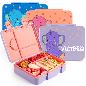 May include: A collection of colorful lunch boxes with elephant designs. One box is open, revealing compartments filled with food like sandwiches, fruit, and snacks. The boxes are blue, orange, pink, and purple, with star patterns and the name "Victoria" on one.