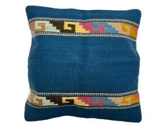 May include: A blue throw pillow with a colorful geometric pattern border. The pillow is made of a soft, woven fabric.