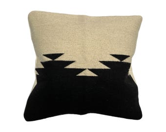 May include: A white and black geometric patterned throw pillow. The pillow is made of a soft, plush fabric and features a black geometric pattern on a white background.