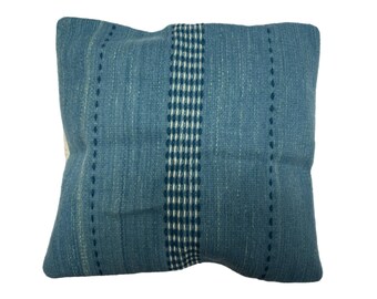 May include: A blue throw pillow with a white and blue patterned stripe down the center.