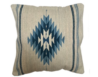 May include: Square decorative pillow with a geometric diamond pattern in shades of blue on a neutral background. The pillow has a textured appearance and features vertical striped accents on the sides.
