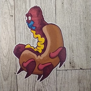 May include: A cartoon hot dog with a red body, yellow mustard, and a brown bun. The hot dog has a blue piece of tape over its mouth and large, round eyes.