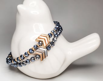 May include: A double-strand bracelet with dark blue faceted beads and gold and silver arrow charms.