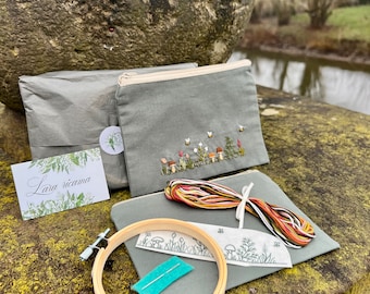 May include: A craft kit for embroidery featuring a gray fabric pouch with an embroidered design of mushrooms and flowers, a hoop, embroidery floss, a needle, and a piece of felt. The kit also includes a card with the text "Lara ricama".