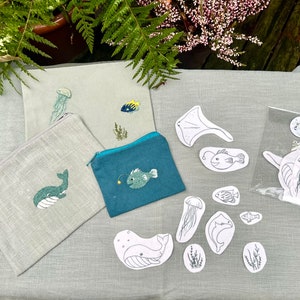 May include: A set of sea creature embroidery patterns and supplies. The set includes a variety of sea creatures, including a whale, a jellyfish, a fish, and a stingray. The patterns are printed on white paper and are ready to be used for embroidery projects. The supplies include a needle, thread, and fabric.