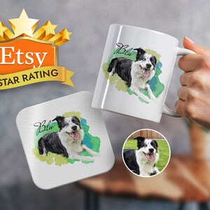 May include: A white ceramic mug featuring a watercolour illustration of a black and white border collie dog with blue eyes. The dog's name "Blu" is written in cursive on the mug. The mug is being held by a hand.