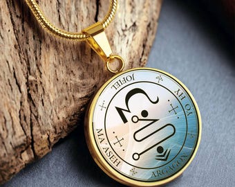 Może przedstawiać: Złoty naszyjnik z okrągłym, niebiesko-białym symbolem przedstawiającym symbol i tekst "Jophiel", "MA'ASEH", "ARGAGON" oraz "YH. YH. YO. HY."