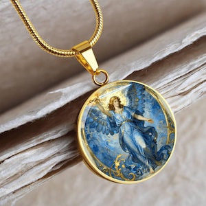 K&ouml;nnte beinhalten: Goldfarbene Halskette mit rundem Anh&auml;nger, der einen Engel in blauem Gewand mit einem Schwert zeigt. Der Engel hat goldenes Haar und Fl&uuml;gel, vor einem blau-goldenen Hintergrund. Die Kette ist goldfarben und strukturiert.