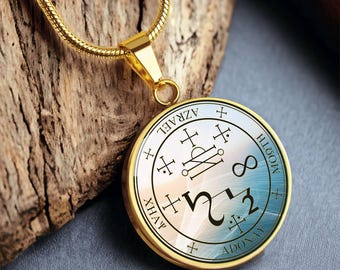May include: Gold chain necklace with a round pendant featuring a blue and white sigil with the words "AZRAEL", "ADONAY", "MOGOTH", "XHAY", and "212" inscribed around the edge.