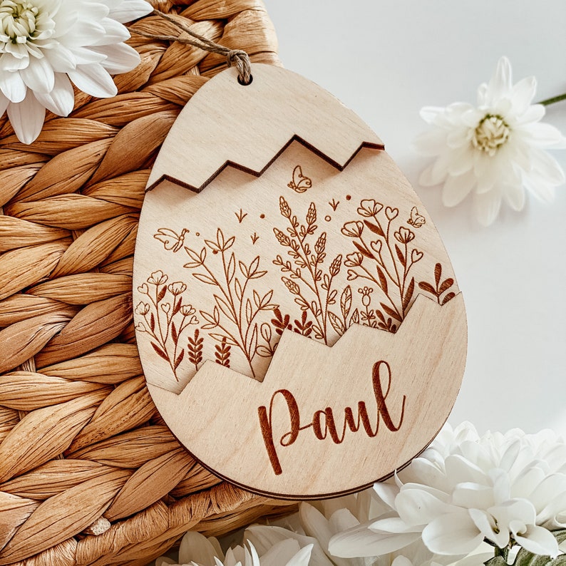 May include: A wooden Easter egg ornament with a cracked design, featuring a floral pattern and the name "Paul" engraved on the bottom.