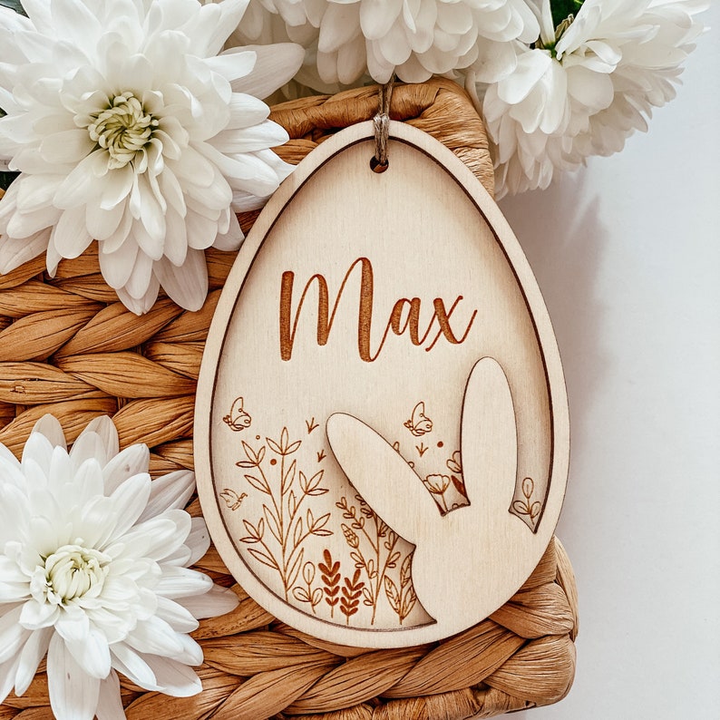 May include: A wooden Easter egg ornament with a bunny silhouette and floral design. The egg is personalized with the name "Max".
