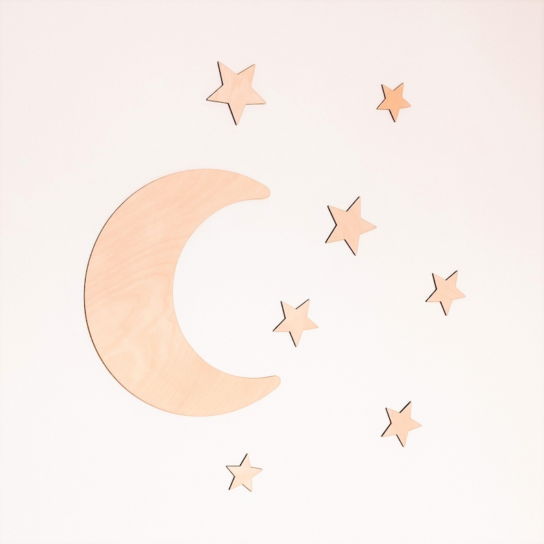 May include: A wooden crescent moon and eight wooden stars in a light brown color against a white background.