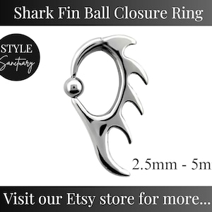 May include: Silver shark fin ball closure ring for body jewellery. The ring is open and has a ball on the end. The ring is 2.5mm to 5mm in diameter.