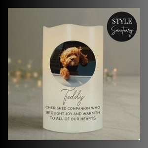 May include: A white candle with a photo of a brown dog looking out of a car window. The candle has the text "Teddy" and "Cherished companion who brought joy and warmth to all of our hearts".