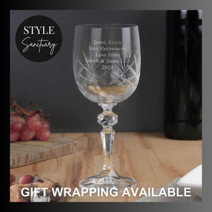 May include: A clear crystal wine glass with a cut design. The glass has an inscription that reads "Janet, Enjoy Your Retirement. Love From Smith & Jones LTD 2024".
