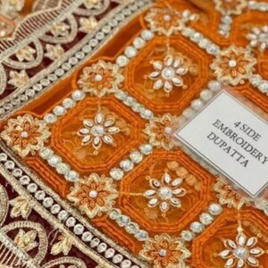 May include: Orange and maroon embroidered fabric with a scalloped edge and a label that reads "4 Side Embroidery Dupatta".