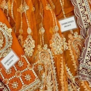 May include: Orange net fabric with gold and silver embroidery. The fabric is decorated with floral and paisley patterns. The fabric is labeled "Embroidered Front", "Embroidered Sleeves", "Embroidered Daman", and "Front Body".