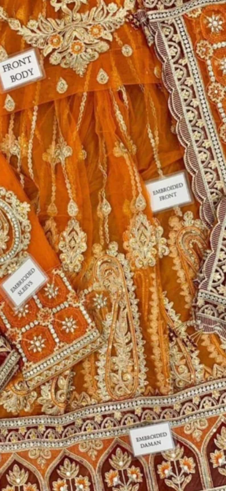 May include: Orange net fabric with gold and silver embroidery. The fabric is decorated with floral and paisley patterns. The fabric is labeled "Embroidered Front", "Embroidered Sleeves", "Embroidered Daman", and "Front Body".