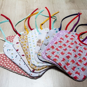 Puede incluir: Una colección de 10 baberos para bebé coloridos con diferentes patrones, incluyendo zorros, osos y diseños geométricos. Los baberos tienen bordes suaves de rizo y lazos ajustables.
