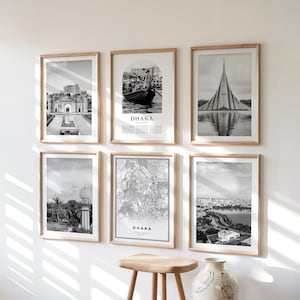 Könnte beinhalten: Sechs gerahmte Schwarz-Weiß-Drucke mit Holzrahmen. Die Drucke zeigen Bilder von Dhaka, darunter Architektur, eine Karte und ein Boot. Das Wort "Dhaka" ist auf einigen der Drucke aufgedruckt.