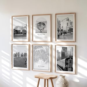 May include: A collection of six framed black and white prints. The prints depict various scenes of Queens, New York, including a bridge, a cityscape, a street scene, a map, and a subway train. The word "QUEENS" is visible on some prints.