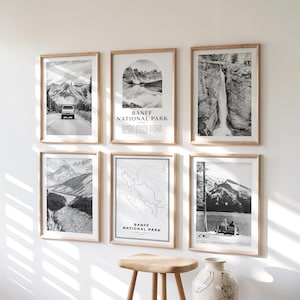 Pode incluir: Seis impressões de paisagens em preto e branco emolduradas com molduras de madeira. As impressões retratam cenas do Parque Nacional de Banff, incluindo montanhas, cachoeiras e um mapa. O texto "BANFF NATIONAL PARK" é visível em duas das impressões.