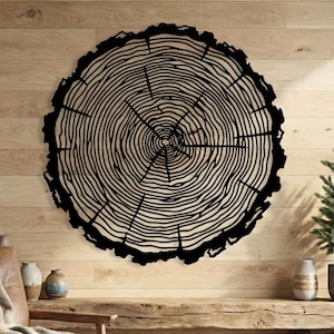 Black metal tree ring wall art, wood slice sign on light wood cabin wall