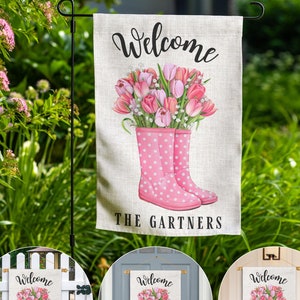 May include: Welcome garden flag with pink rain boots and a bouquet of pink tulips. The text "Welcome The Gartners" is printed on the flag.