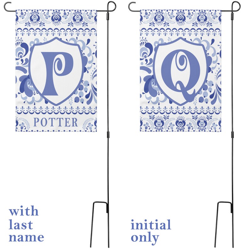 May include: Two blue and white garden flags with a floral pattern. The flag on the left has a blue letter "P" in a white shield with the word "POTTER" below it. The flag on the right has a blue letter "Q" in a white shield. Both flags are attached to black metal poles.