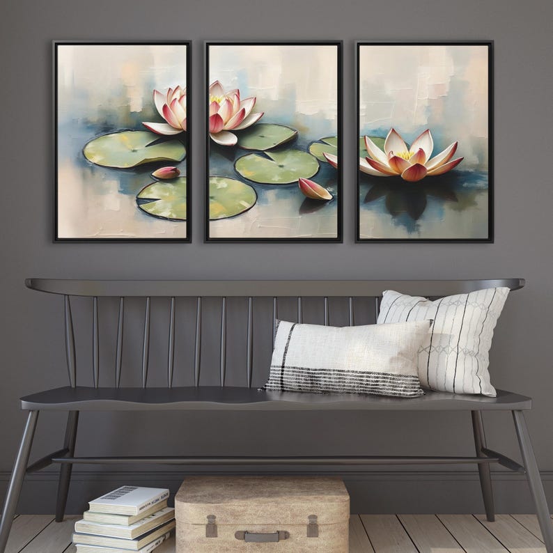 May include: Triptych of framed art prints featuring water lilies. Each print showcases a lily with pink and white petals, green lily pads, and a soft, abstract background in shades of blue and beige. The artwork is displayed above a gray bench.