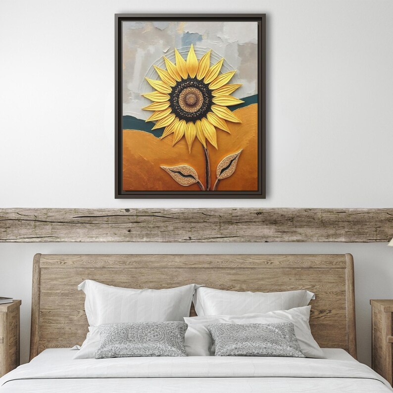 Puede incluir: Una obra de arte en lienzo enmarcada con un girasol texturizado. El girasol tiene p&eacute;talos amarillos y un centro marr&oacute;n oscuro. El fondo tiene tonos de naranja, verde y gris. La obra de arte se exhibe sobre un cabecero de madera.