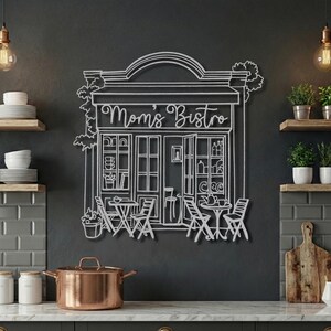 Silver raw steel custom kitchen sign reading "Mom's Bistro" mounted on a dark grey wall above a counter.