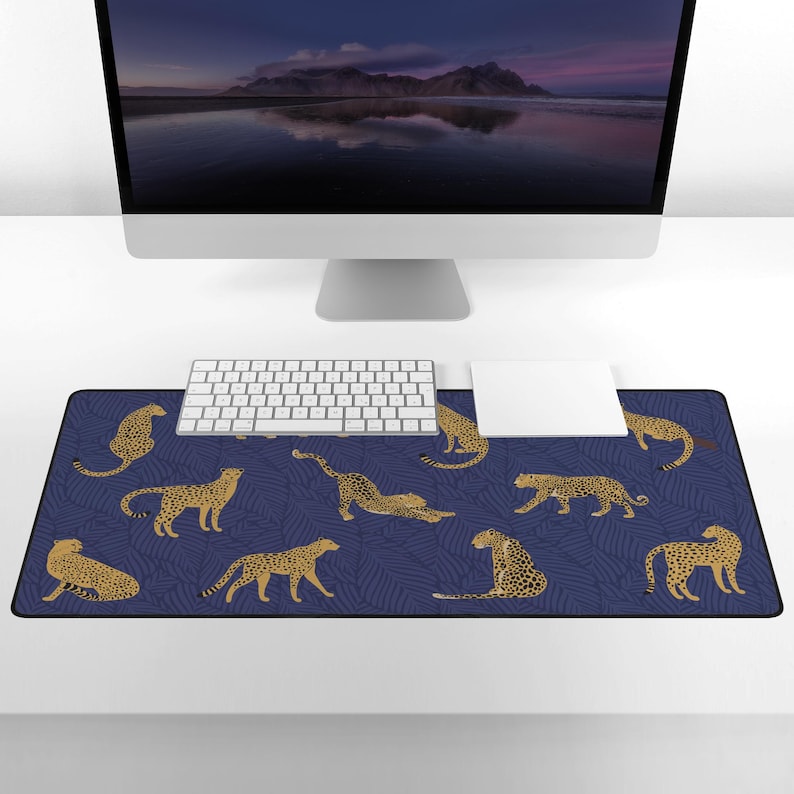 May include: A blue and gold leopard print mouse pad with a white keyboard and mouse on a white desk.