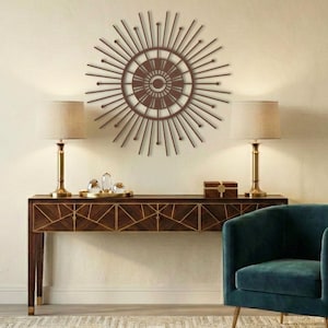 Copper finished mid century modern sun wall piece hanging above a wooden credenza.