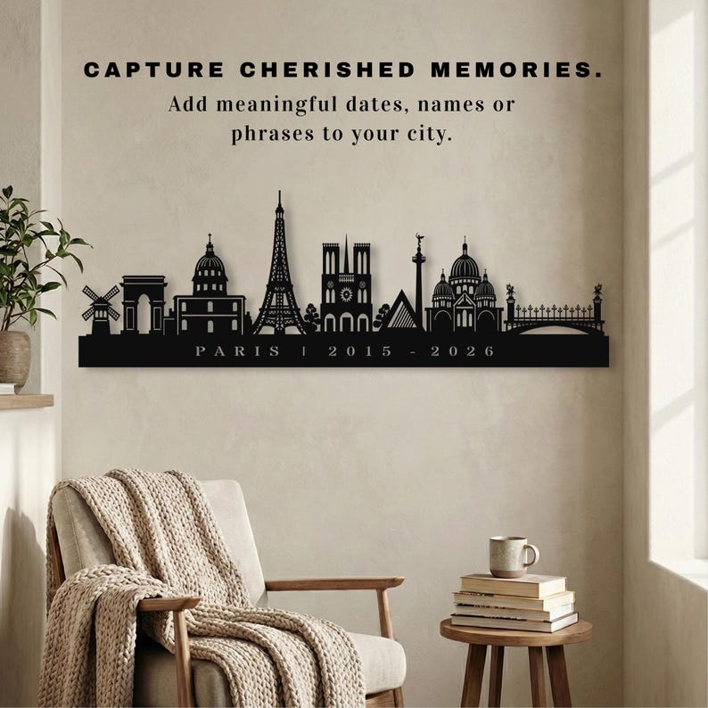 May include: Black metal wall art featuring the Paris skyline, with the Eiffel Tower and Notre Dame Cathedral. The word "PARIS" and the dates "2015 - 2026" are below. The text above reads "CAPTURE CHERISHED MEMORIES. Add meaningful dates, names or phrases to your city."