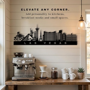 May include: A black metal Las Vegas skyline wall art piece. The artwork features iconic landmarks and the city's name. Text above reads "ELEVATE ANY CORNER. Add personality to kitchens, breakfast nooks and small spaces."