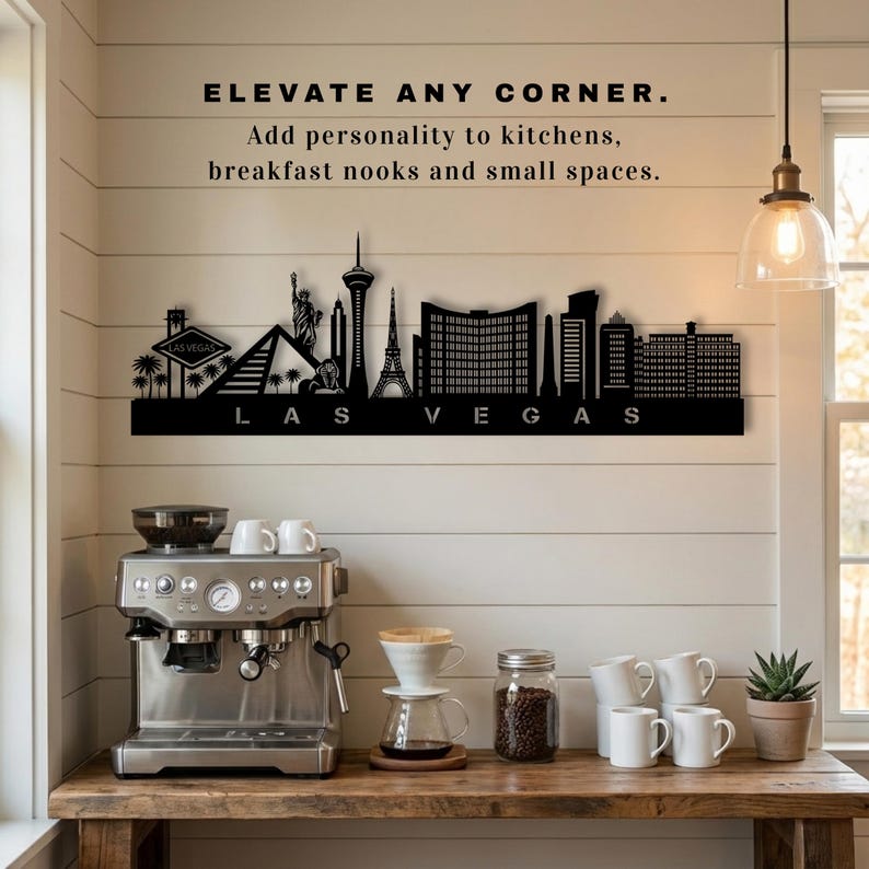 May include: A black metal Las Vegas skyline wall art piece. The artwork features iconic landmarks and the city's name. Text above reads "ELEVATE ANY CORNER. Add personality to kitchens, breakfast nooks and small spaces."