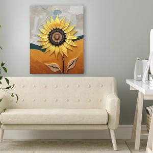 Puede incluir: Impresi&oacute;n en lienzo enmarcada que representa un gran girasol texturizado. Los p&eacute;talos son amarillos y el centro es marr&oacute;n oscuro. El fondo presenta tonos de amarillo, azul y gris. La obra de arte est&aacute; sobre un sof&aacute; color crema.
