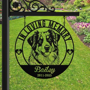 May include: Black metal memorial sign with a dog portrait, paw prints, and the text "In Loving Memory." The dog's name, "Bailey," and dates 2011-2025 are displayed below the portrait. The sign is hanging from a decorative black metal bracket.