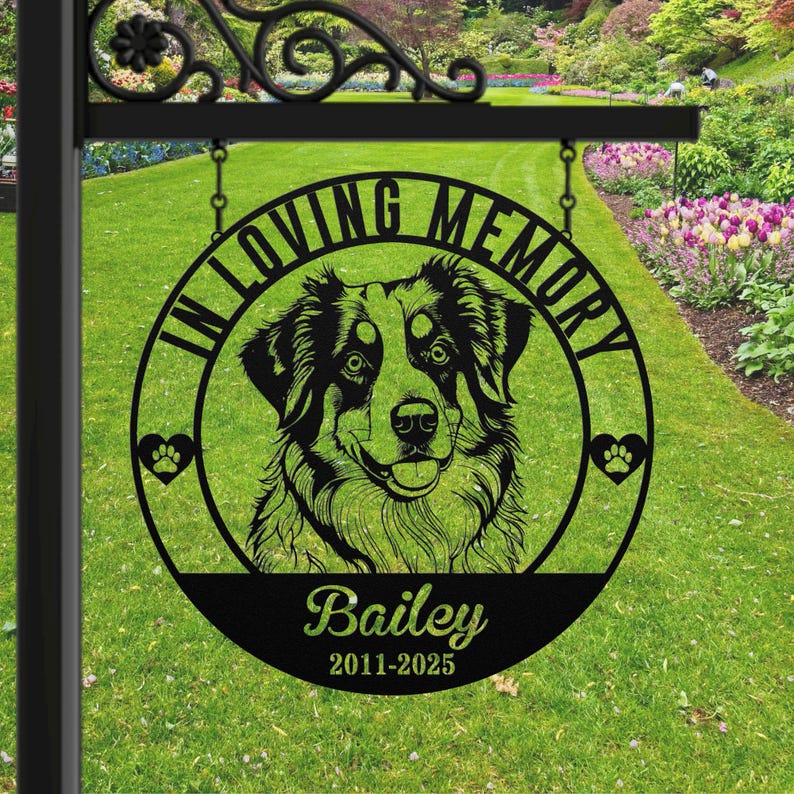 May include: Black metal memorial sign with a dog portrait, paw prints, and the text "In Loving Memory." The dog's name, "Bailey," and dates 2011-2025 are displayed below the portrait. The sign is hanging from a decorative black metal bracket.