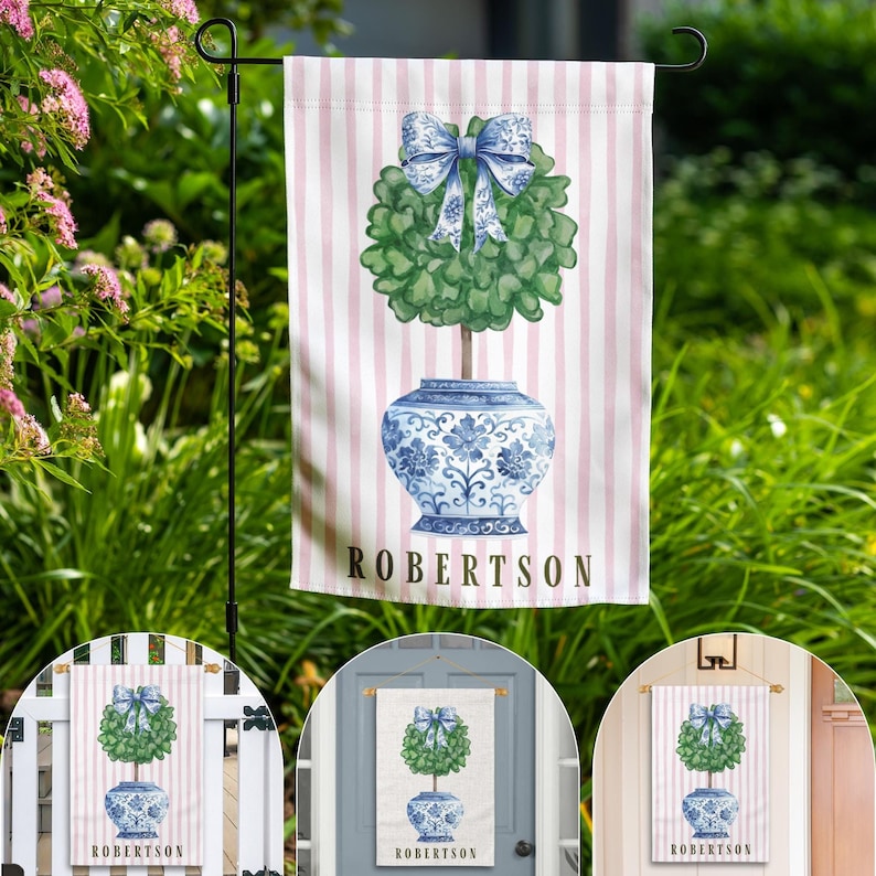 May include: A pink and white striped garden flag with a blue and white porcelain planter with a green topiary tree and a blue bow. The text "ROBERTSON" is printed on the flag.
