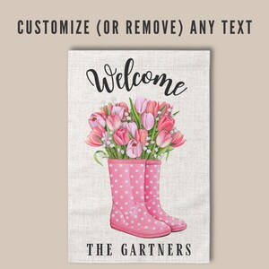 May include: A welcome garden flag with a pink polka dot rain boot filled with pink tulips. The text "Welcome" and "The Gartners" is printed on the flag.