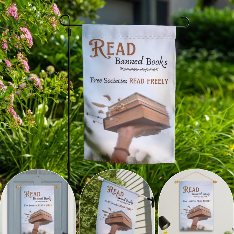 Może przedstawiać: Biała flaga ogrodowa z tekstem "READ Banned Books Free Societies READ FREELY" i ilustracją dłoni trzymającej stos książek.