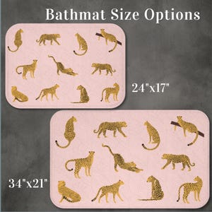 May include: Two bath mats with a pink background and a cheetah print pattern. The smaller bath mat is 24 inches by 17 inches. The larger bath mat is 34 inches by 21 inches. Both bath mats feature a cheetah print pattern with gold cheetahs.