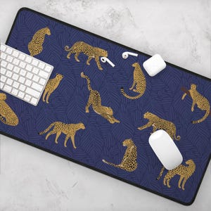 May include: A blue and gold mousepad with a repeating pattern of leopards on a dark blue background with palm leaves.