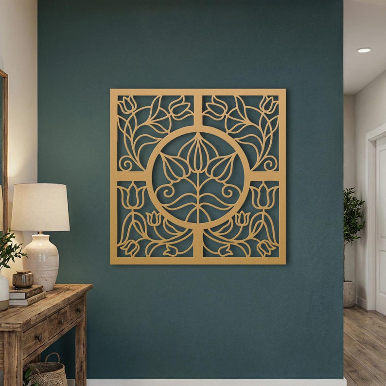 May include: A square wooden wall art piece with a floral design. The artwork features a central circular motif surrounded by a square frame, all cut from light-coloured wood. The design includes stylised flowers and leaves, creating a decorative element.
