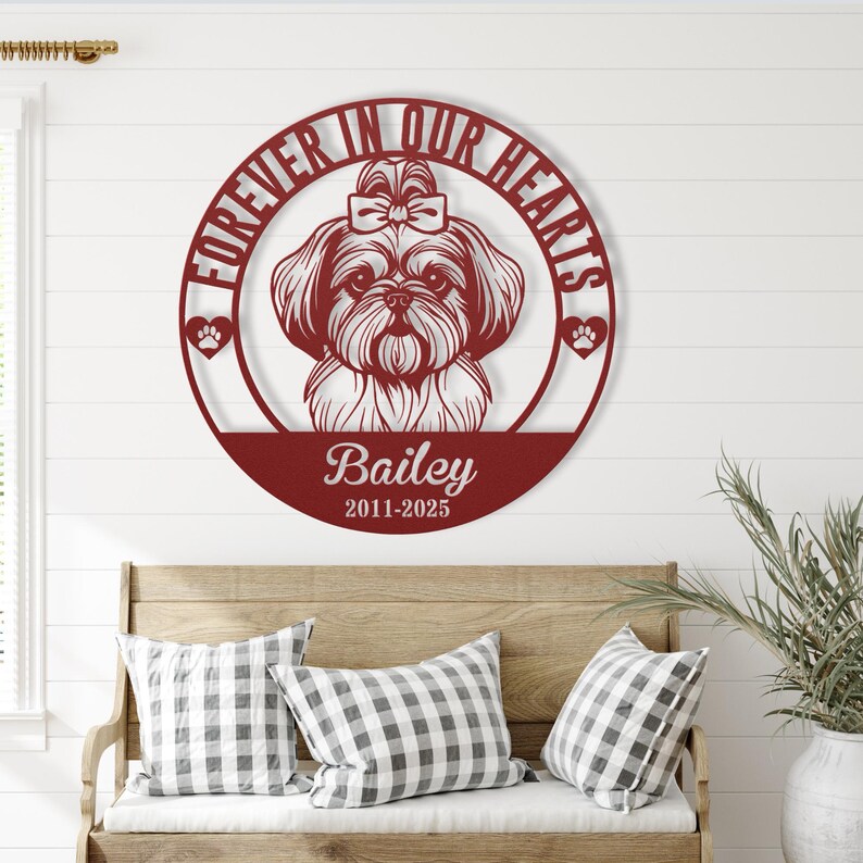 Puede incluir: Una pieza de arte mural de metal burdeos con un dise&ntilde;o de perro Shih Tzu. El marco circular dice "Forever in Our Hearts" e incluye el nombre "Bailey" y las fechas "2011-2025". Huellas de patas y un lazo acent&uacute;an el dise&ntilde;o.