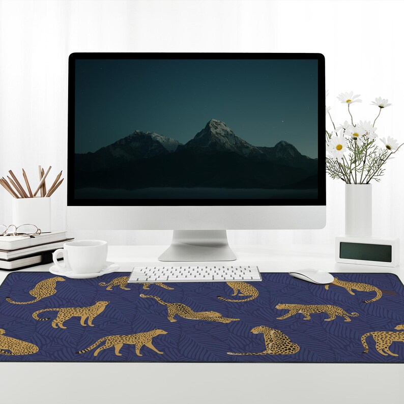 May include: A blue and gold leopard print mousepad with a computer monitor, keyboard, and mouse on a white desk.
