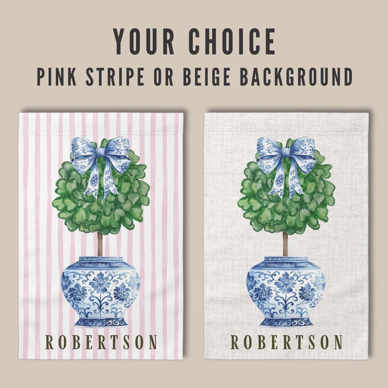May include: Two garden flags with a blue and white porcelain pot with a green topiary tree and a blue bow. The flag on the left has a pink and white striped background and the flag on the right has a beige background. Both flags have the name "ROBERTSON" printed at the bottom.